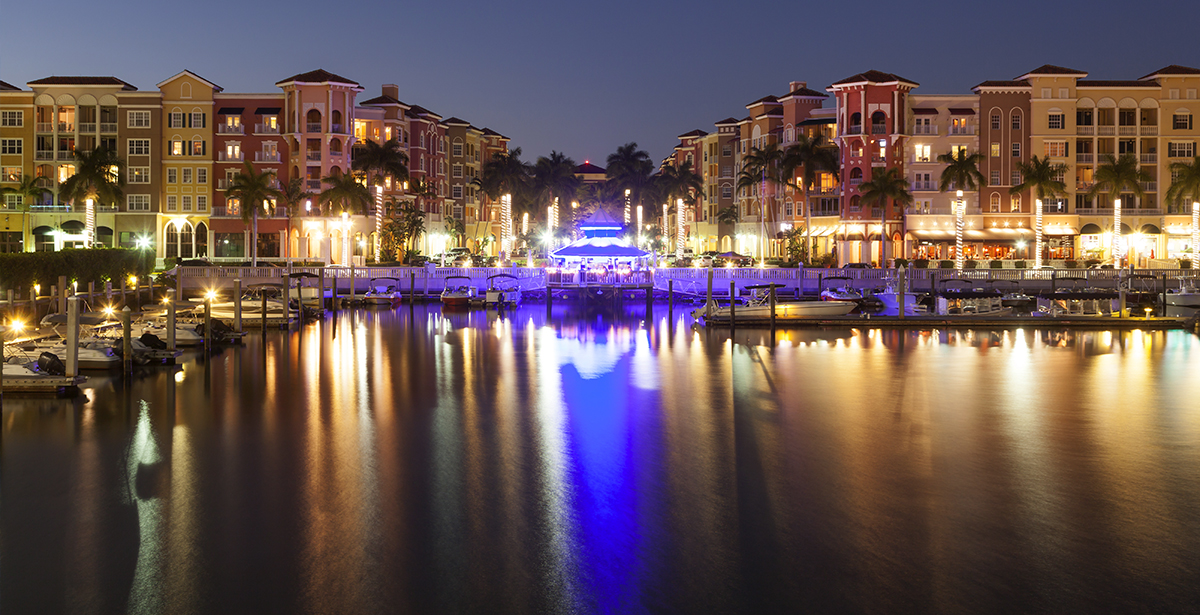 A view of a marina in downtown Naples at night.